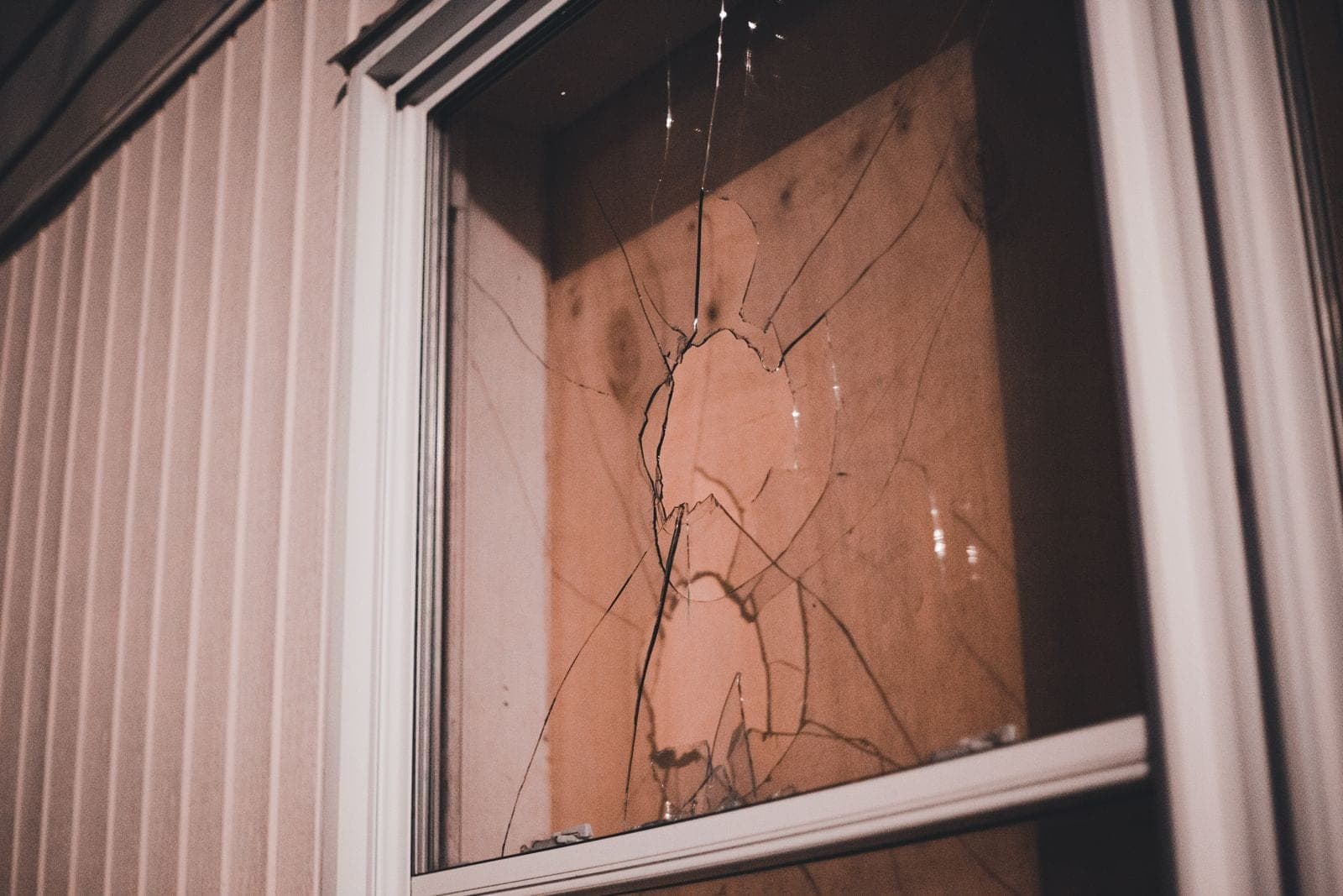 Hail damage window replacement in Red Deer: cracked window pane in a white frame