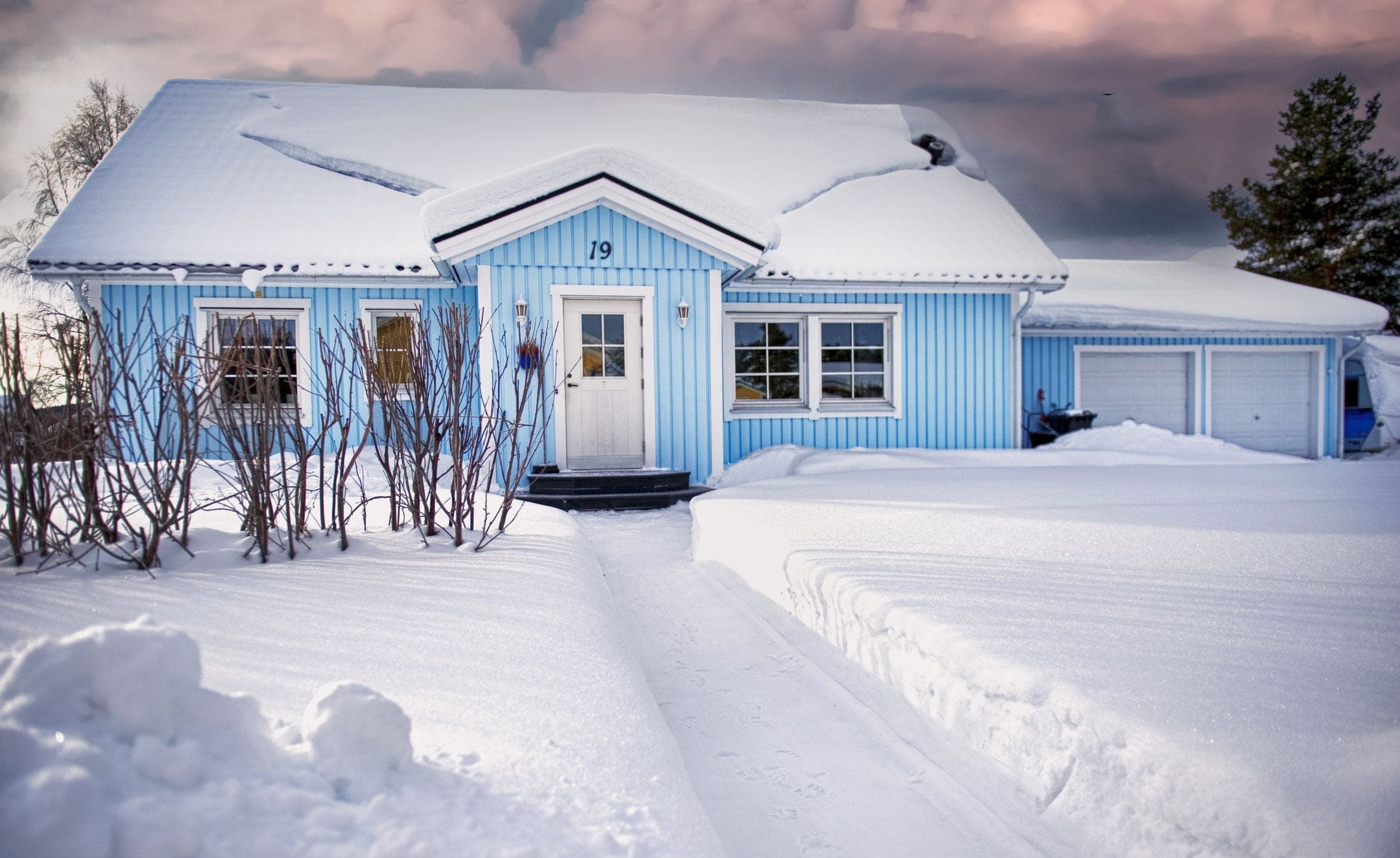 Window replacement near Red Deer: light blue house with a shovelled front walk after a snowfall