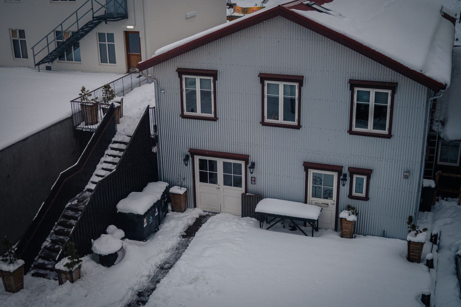 Window replacement in Sundre: two-storey house with wood stairs and a snowy yard